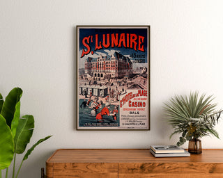 Vintage plakat Bretagne – Saint-Lunaire, havbade, indrammet over en trækommode mellem planter.