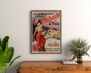 Vintage plakat Bretagne – Saint-Malo, casinoåbning, indrammet over en trækommode mellem planter.