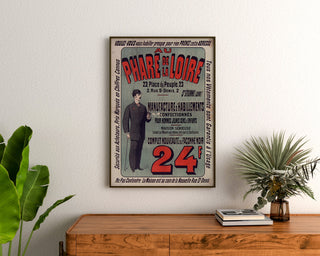Vintage reklameplakat Au Phare de la Loire, beklædning, indrammet over en kommode i træ mellem planter.