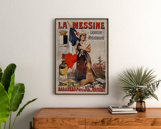 Vintage reklameplakat La Messine, likør, indrammet over en trækommode mellem planter.