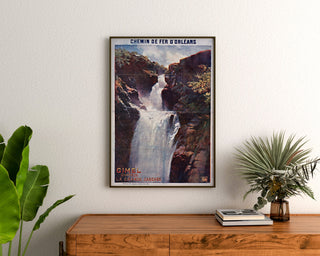 Vintage turistplakat – Gimel, la Grande Cascade, indrammet over en trækommode mellem planter.