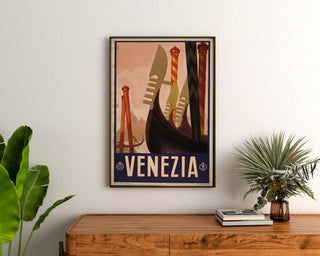 Vintage turistplakat – Venezia, gondolforstævn, indrammet over en trækommode mellem planter.