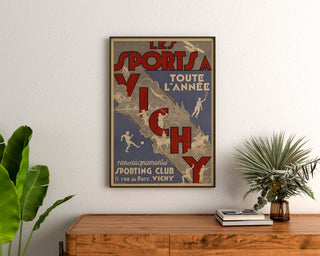 Vintage turistplakat – Vichy, sport året rundt, indrammet over en trækommode mellem planter.