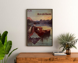 Vintage plakat "Aix-les-Bains, billets collectifs PLM" indrammet over et trækommode mellem planter.