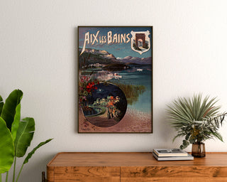 Vintage plakat "Aix-les-Bains, fête de nuit" indrammet over et trækommode mellem planter.