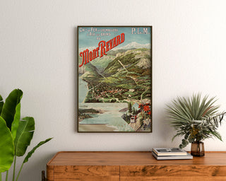 Vintage plakat "Aix-les-Bains, Mont-Revard, crémaillère" indrammet over et trækommode mellem planter.