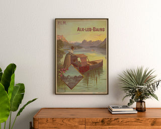 Vintage plakat "Aix-les-Bains, PLM" indrammet over et trækommode mellem planter.