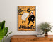 Vintageplakat Dudley Hardy, comic guide, indrammet over en trækommode mellem planter.