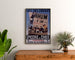 Vintage plakat Épicerie Lefèvre, kaffe og chokolade, indrammet over en kommode i træ, flankeret af planter.