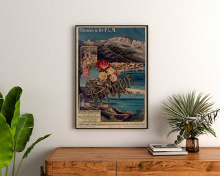 Vintage plakat La Turbie, PLM-jernbaner, indrammet over en trækommode mellem planter.