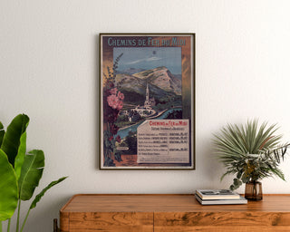 Vintage-plakat Lourdes, badebyer, indrammet over en trækommode mellem planter.