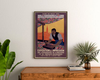 Vintage-plakat Mulhouse, litografisk udstilling, indrammet over en trækommode mellem planter.