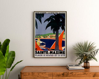 Vintage plakat Sainte-Maxime, côte des Maures, indrammet over en kommode i træ, mellem planter.