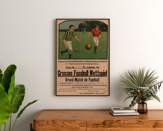 Vintage plakat Sarreguemines, fodboldkamp, indrammet over en trækommode mellem planter.