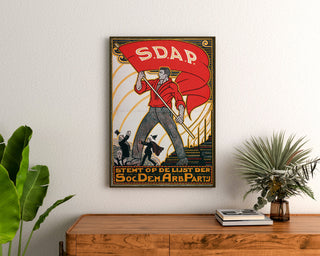 Vintage plakat Stemt SDAP, valg, indrammet over en kommode i træ mellem planter.