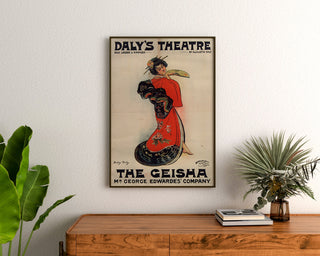 Vintageplakat The Geisha, Daly’s Theatre, indrammet over en trækommode mellem planter.